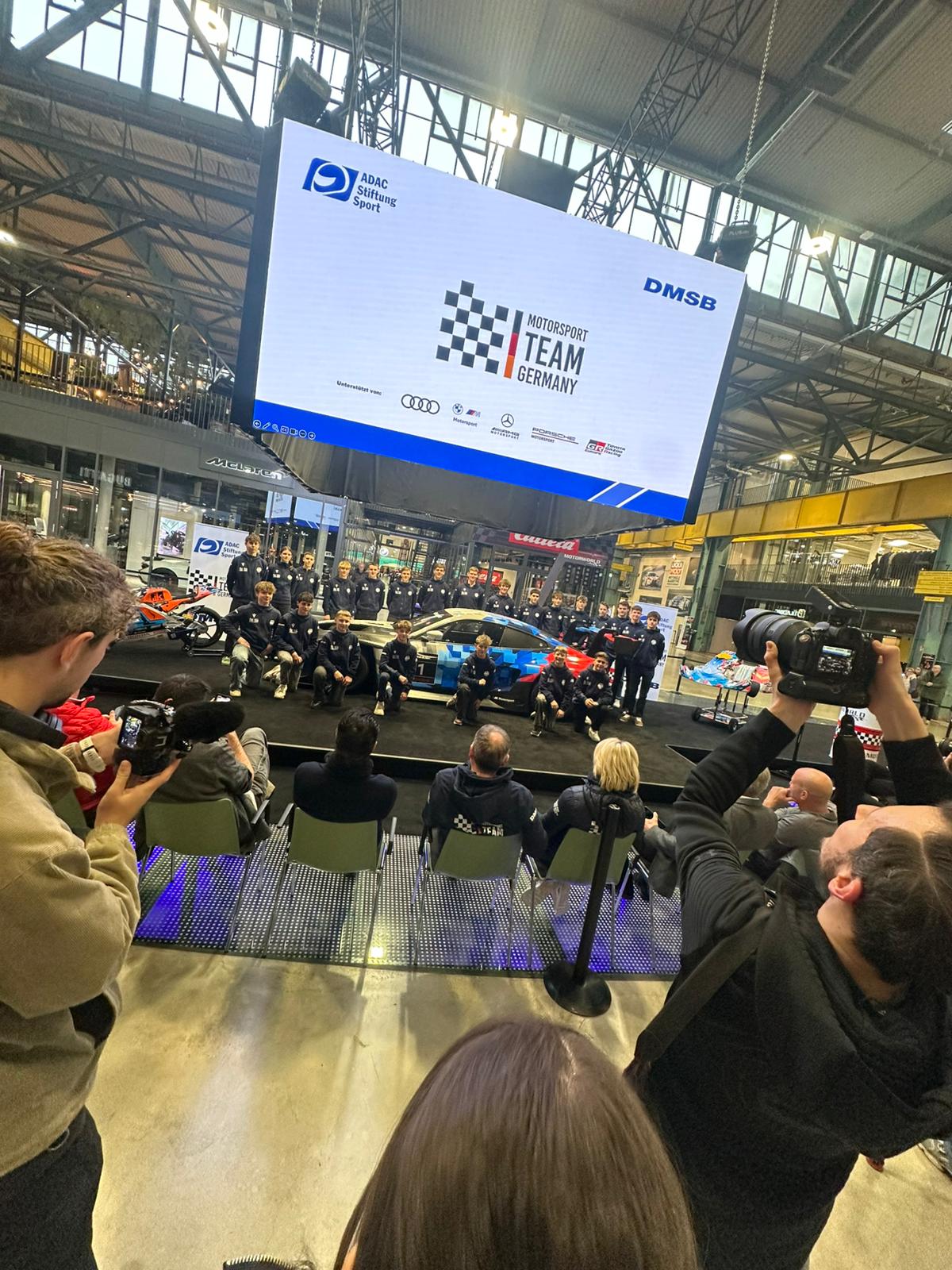 Vorstellung eines Motorsport-Förderkaders auf einer Bühne mit großer Leinwand